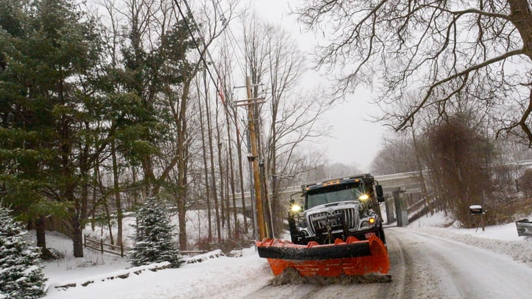A snowplow removes the snow on Maple Street in Brattleboro,...