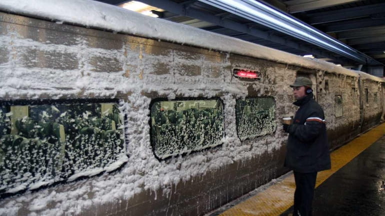 FILE - A snow-covered train arrives at the LIRR Jamaica...