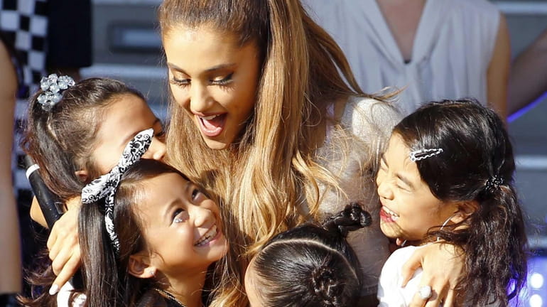U.S. singer Ariana Grande hugs children during an event to...