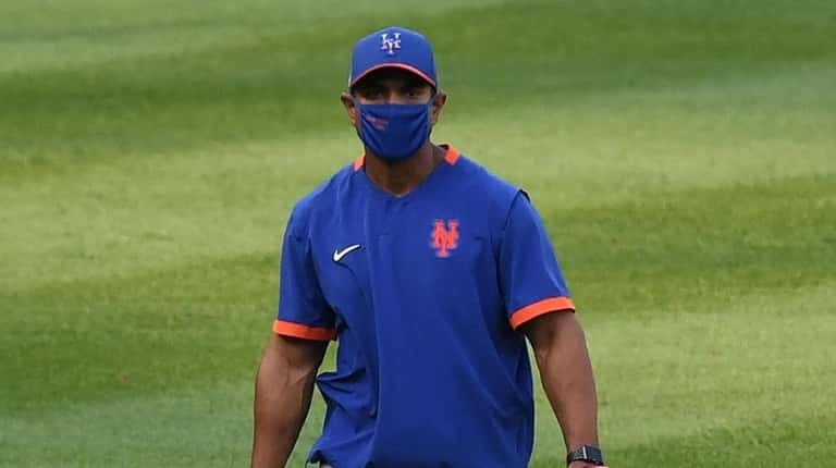 Mets manager Luis Rojas walks in from the outfield before...