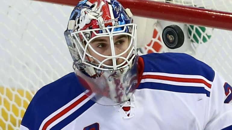 Rangers' Cam Talbot keeps his eyes on a flying puck....