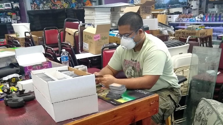 Kush Singhal sorts collectible cards from a new delivery to...