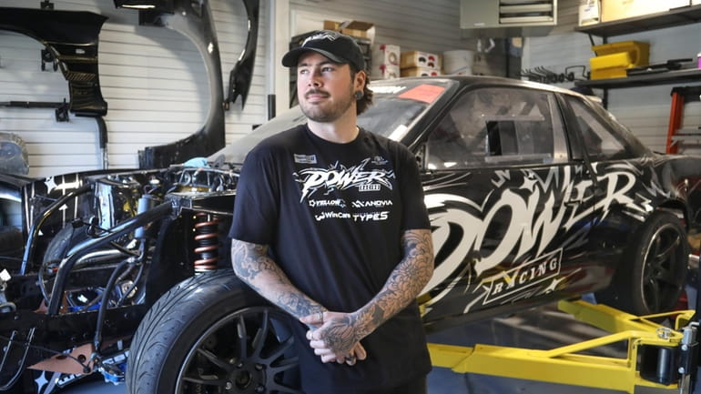 Drift racer Mike Power is shown in the garage of...