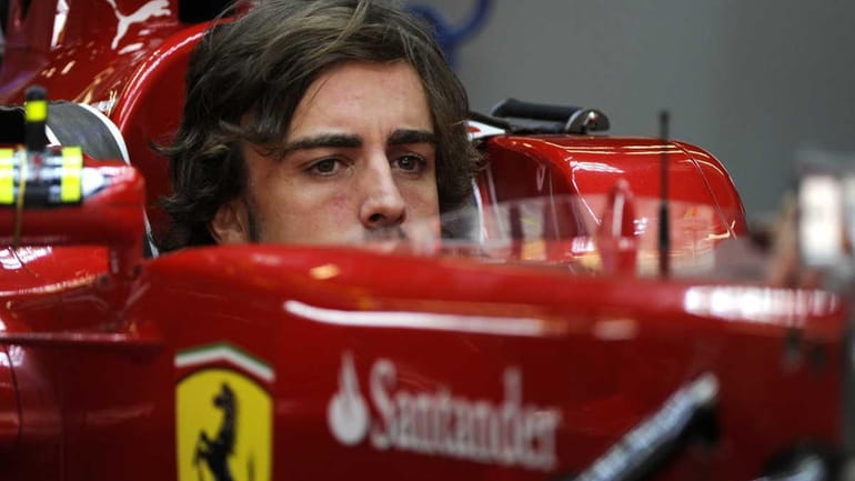 Ferrari driver Fernando Alonso of Spain checks his car before...