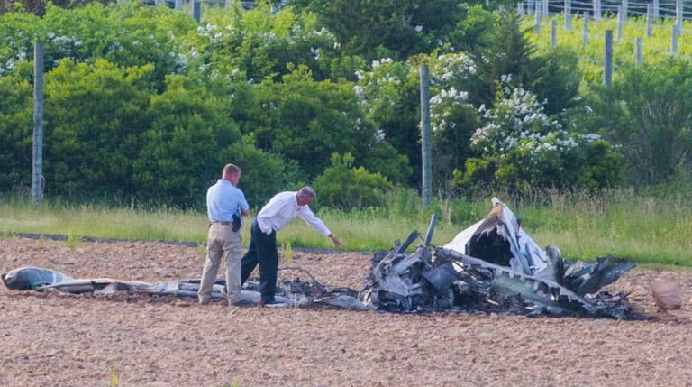 Brian Rayner, right, Air-Safety investigator with NTSB investigates the site where a...