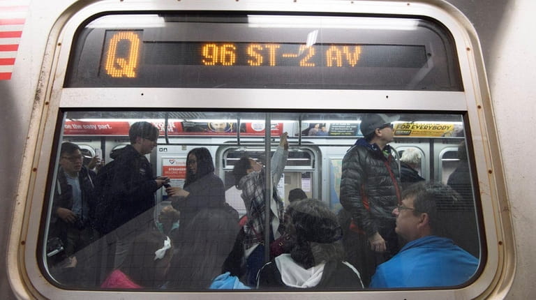 Passengers ride the first northbound Q train during the first...