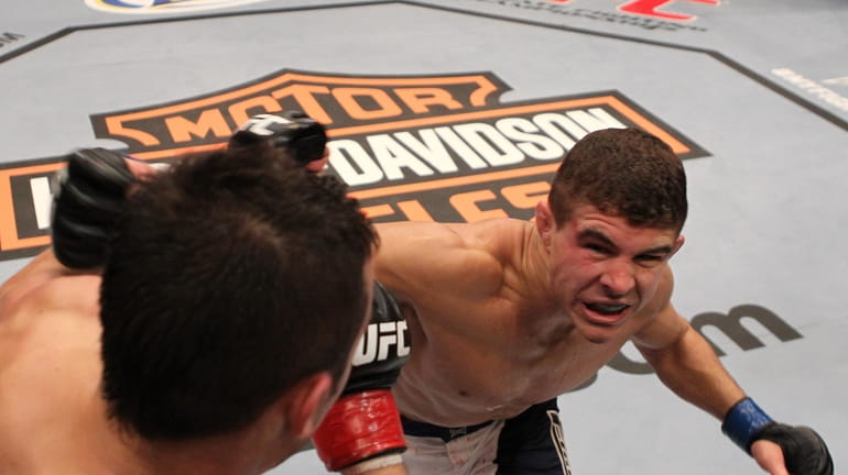 Al Iaquinta, right, lands a punch on Myles Jury during...