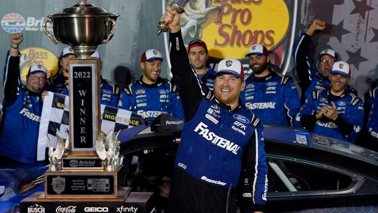 FILE - Chris Buescher celebrates with his trophy and sword...