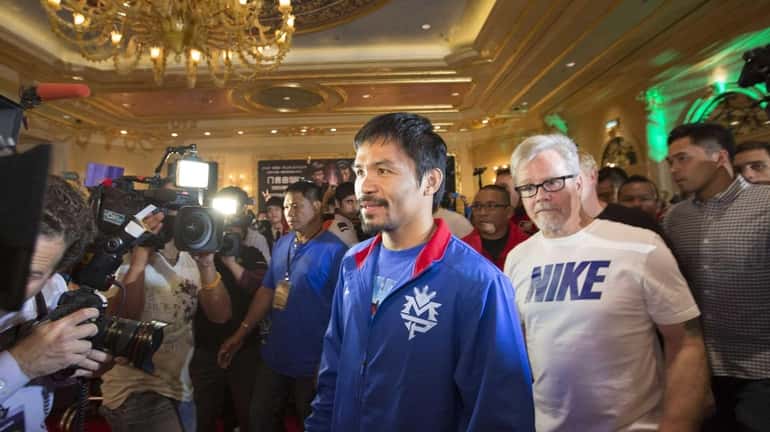 Manny Pacquiao, center,and his trainer Freddie Roach arrive at the...