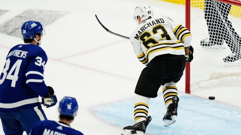 Boston Bruins' Brad Marchand (63) scores an empty-net goal as...