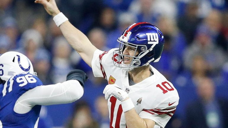Eli Manning #10 of the Giants throws a pass downfield...