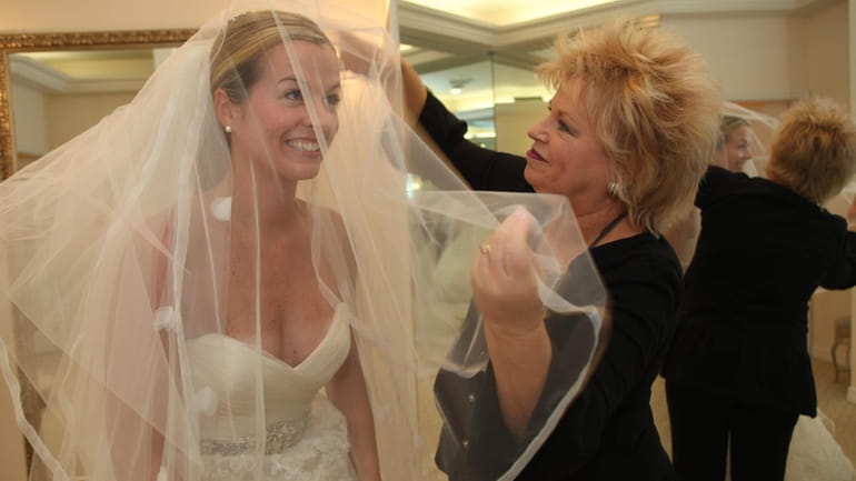 Nancy Aucone, co-owner of The Wedding Salon in Manhasset, places...
