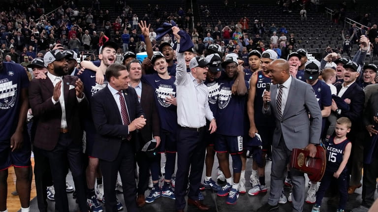 UConn head coach Dan Hurley, middle, celebrates with his team...