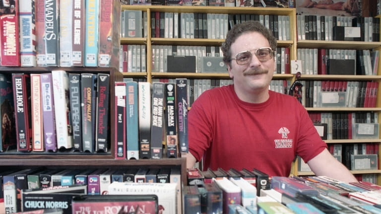 Richard V. Colossi, owner of Video Ventures, posing with VHS...