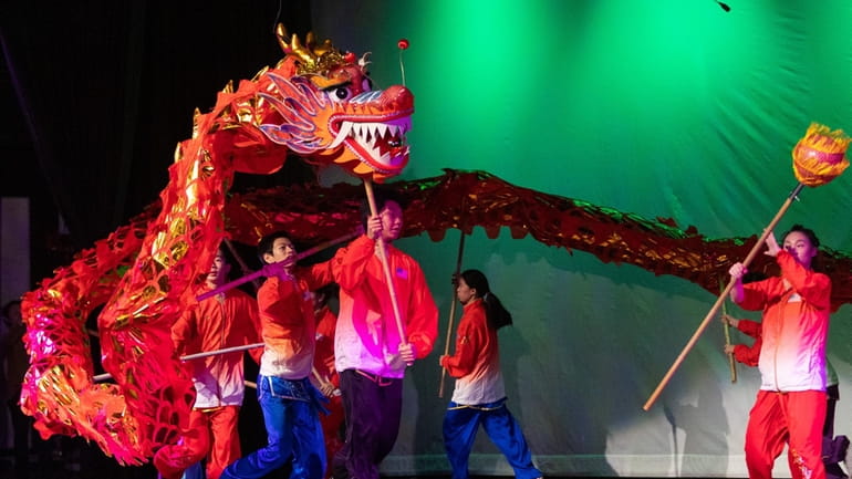 Students perform a dragon dance at a Lunar New Year...