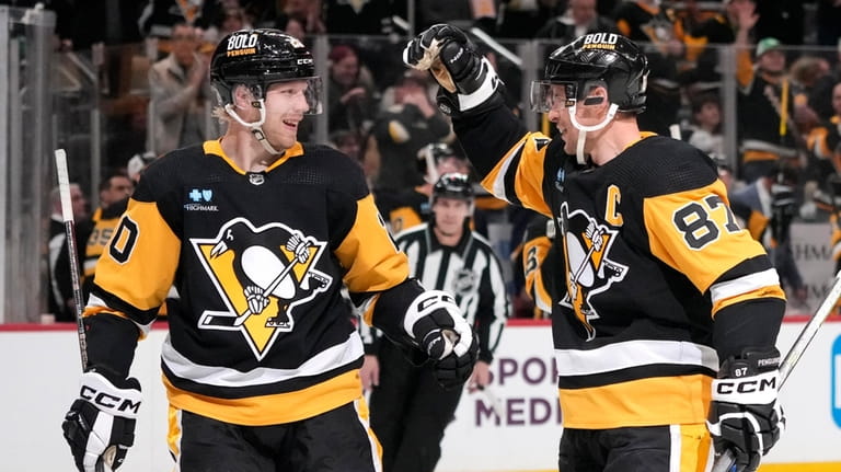 Pittsburgh Penguins' Lars Eller (20) celebrates with Sidney Crosby (87)...