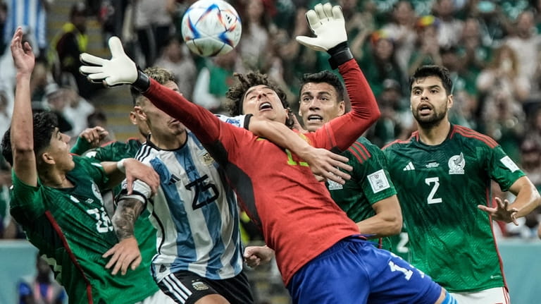 FILE - Mexico's goalkeeper Guillermo Ochoa goes for the ball...
