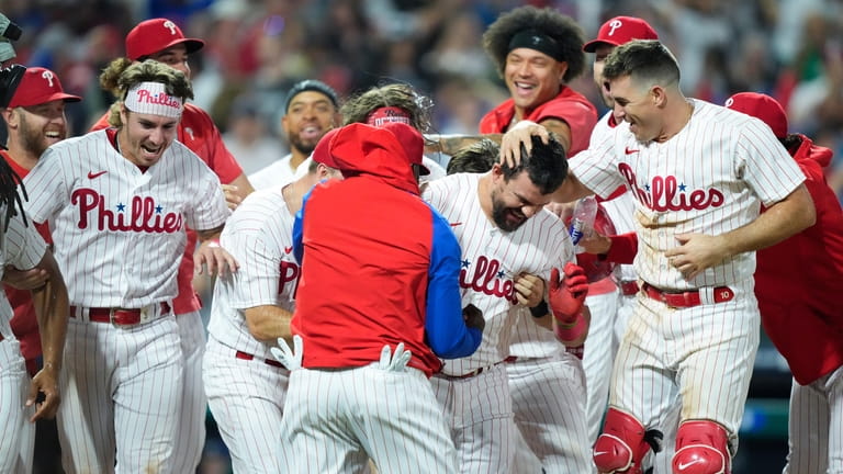 Philadelphia Phillies' Kyle Schwarber, center right, celebrates with teammates after...