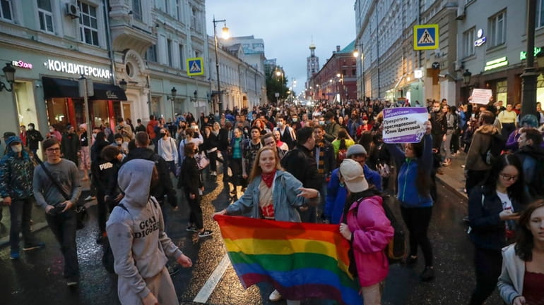 LGBT activists hold their flag at a rally to collect...