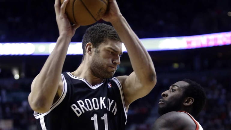 Nets center Brook Lopez, left, works the ball against Portland...