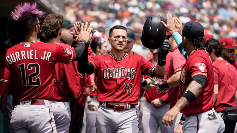 Arizona Diamondbacks' Nick Ahmed is greeted in the dugout after...