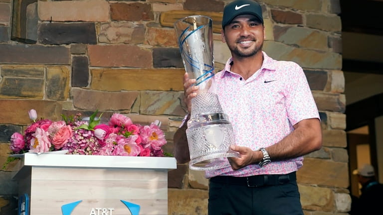 Jason Day, of Australia, poses for photos with the trophy...