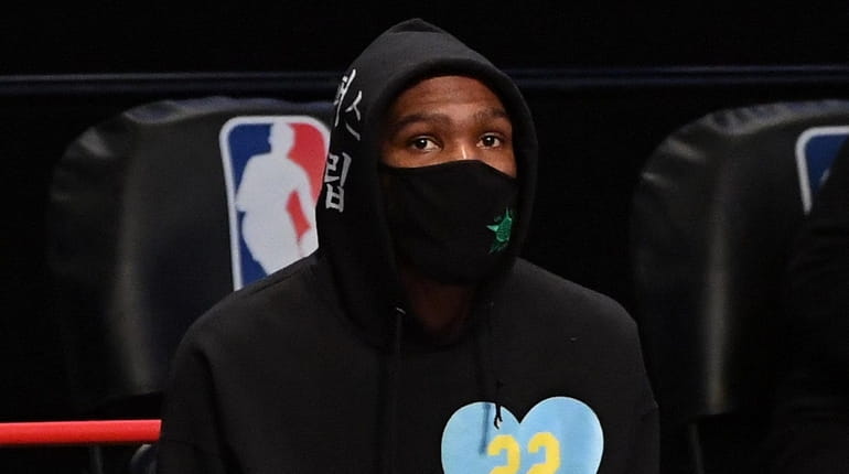 Nets forward Kevin Durant looks on from the bench during...