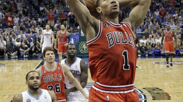 Chicago Bulls' Derrick Rose (1) dunks the ball after getting...