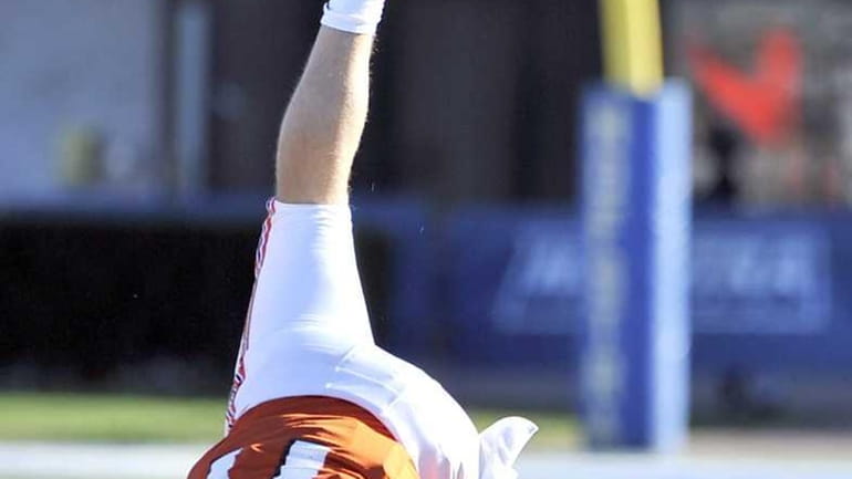 Carey's Quarterback Kyle Zahradka does a handstand as he tries...