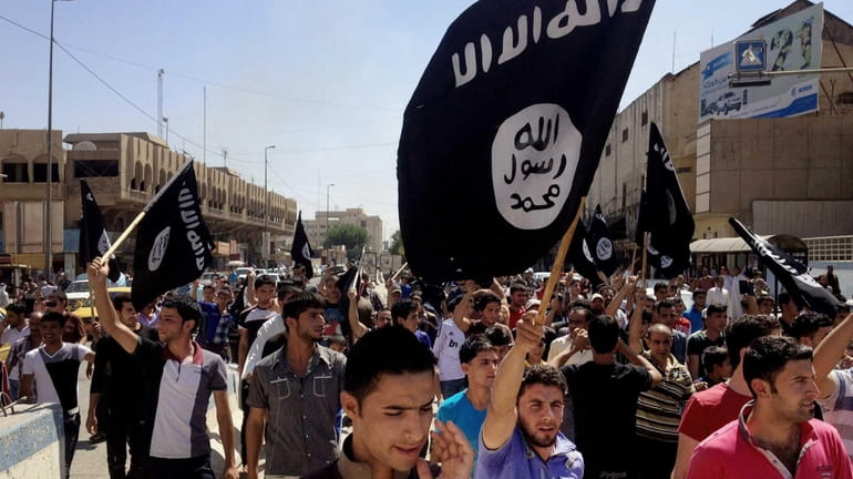 Demonstrators chant pro-Islamic State group slogans as they carry the...
