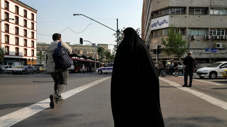 People cross an intersection in downtown Tehran, Iran, Sunday, April...
