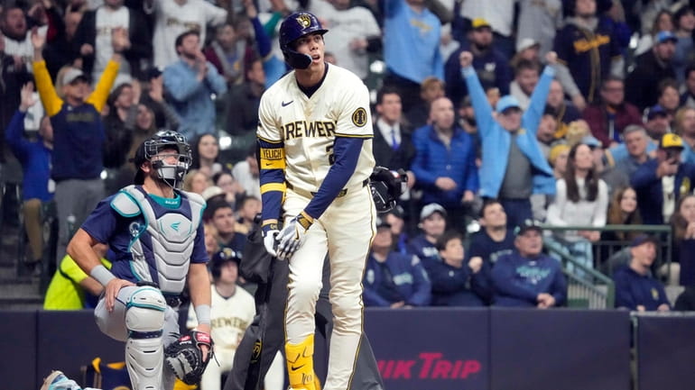 Milwaukee Brewers' Christian Yelich, right, watches his home run during...