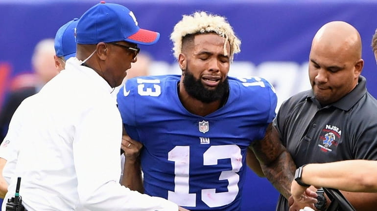 Giants receiver Odell Beckham Jr. is assisted onto a cart...