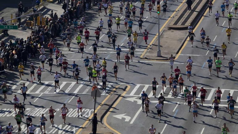 Runners jog through Park Slope in Brooklyn while competing in...