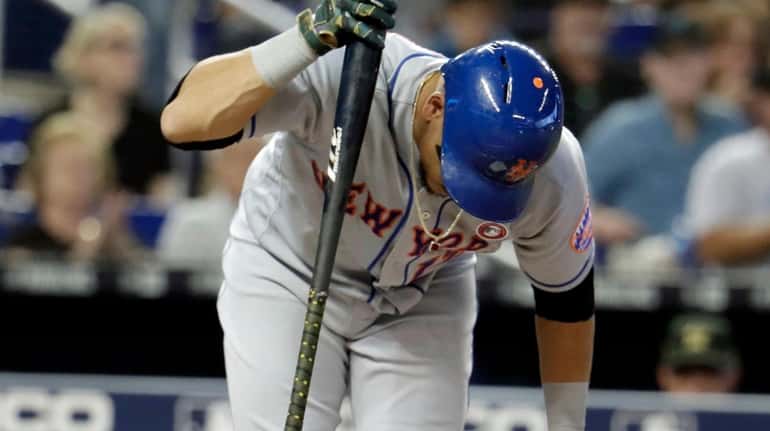 New York Mets' Juan Lagares reacts after he striking out...