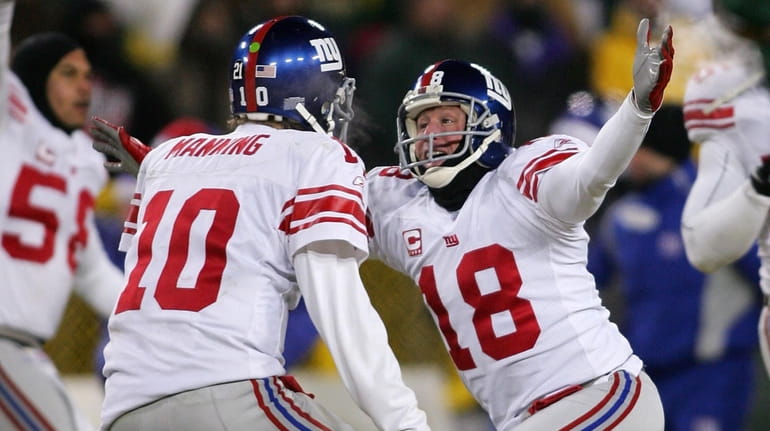 Jeff Feagles and Eli Manning celebrate after kicker Lawrence Tynes kicks...
