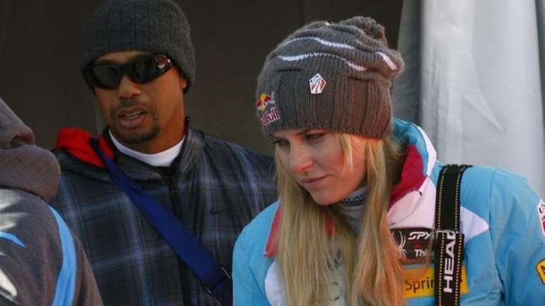Lindsey Vonn is flanked by her boyfriend Tiger Woods as...