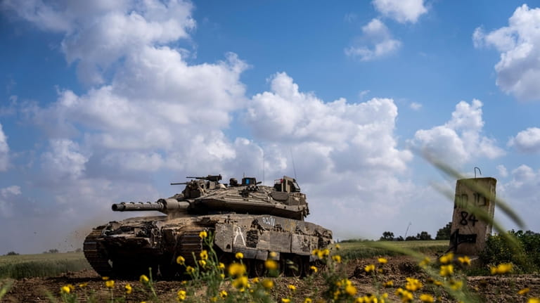Israeli soldiers drive a tank on the border with Gaza...