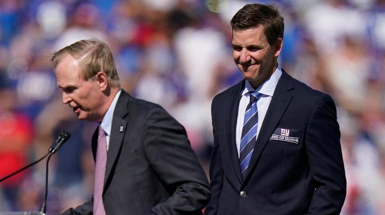 Former New York Giants quarterback Eli Manning, right, smiles as...