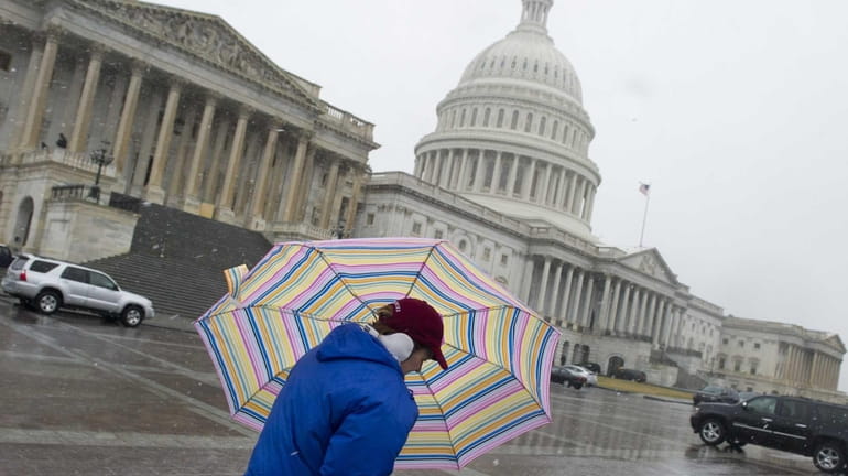 A woman walks past the US Capitol in Washington, D.C....