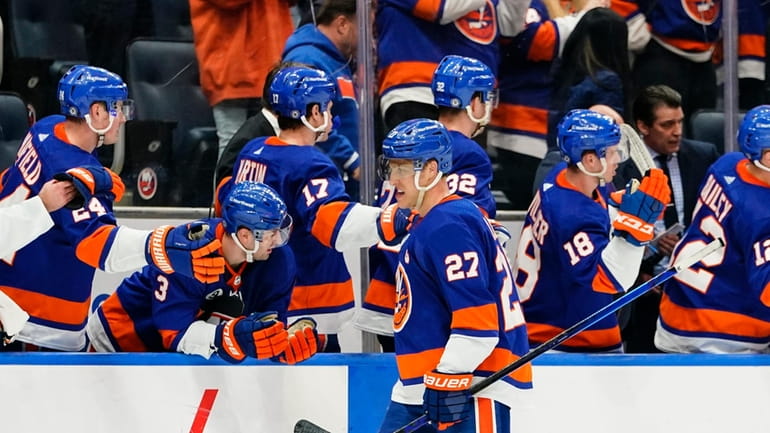 Islanders' Anders Lee (27) is congratulated by teammates after scoring...