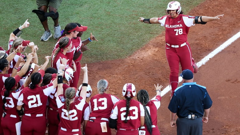 Oklahoma players cheer Jocelyn Alo (78), who approaches home after...