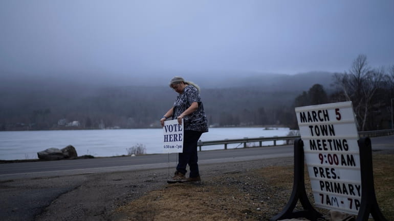 Town Clerk Sandra Lacasse, places a sign outside the town...
