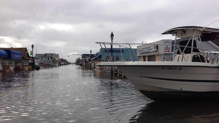 Boats float Tuesday morning along Woodcleft Avenue in Freeport, brought...