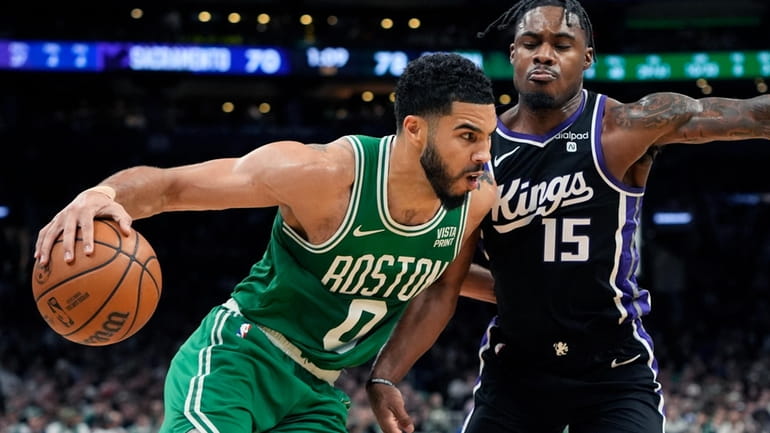 Boston Celtics' Jayson Tatum (0) drives past Sacramento Kings' Davion...