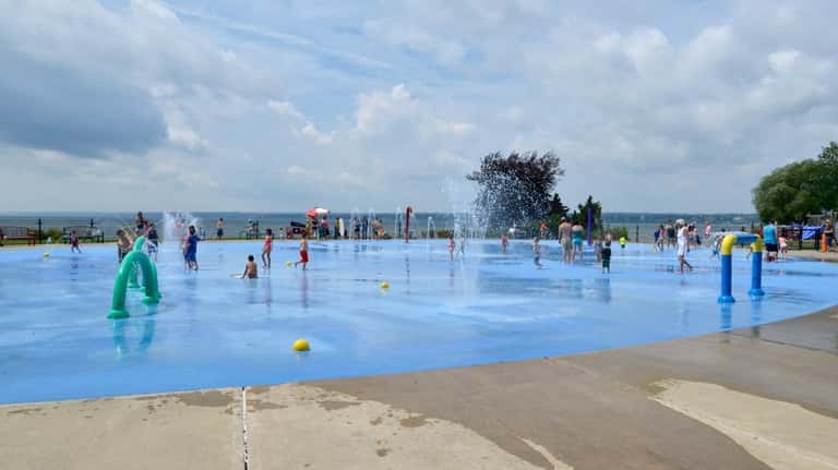 Visitors frolick in a sprinkler pool at Seneca Lake State...