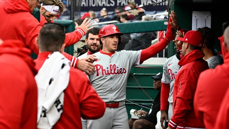 Philadelphia Phillies' J.T. Realmuto, center, celebrates after he scored on...