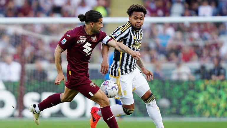 Torino's Ricardo Rodriguez, left, fights for the ball with Juventus'...