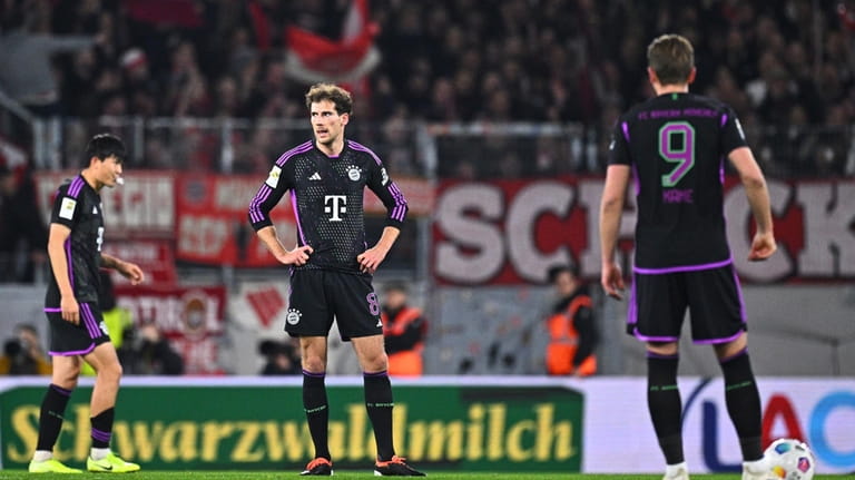 Bayern Munich players react after receiving a goal during the...