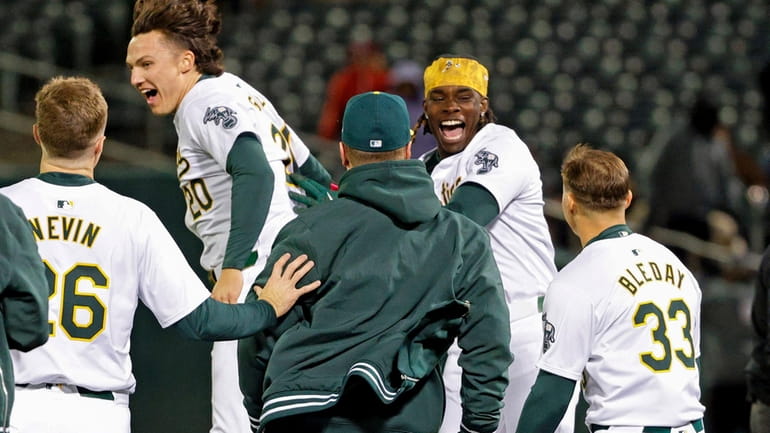 Oakland Athletics right fielder Lawrence Butler, second from right, celebrates...